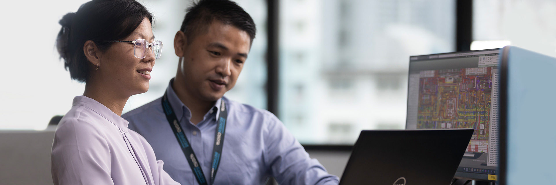 Two BEUMER electrical engineers in Singapore look at computer